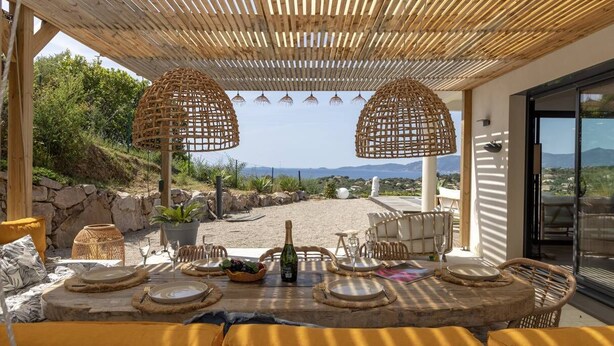 An outdoor dining area with a view of the landscape, wicker furniture, and a table set for a meal. - Villa LAETIZIA- 5 bedrooms, swimming pool, sea view (PIETROSELLA)