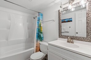 Un bagno con vasca, water e lavandino.
