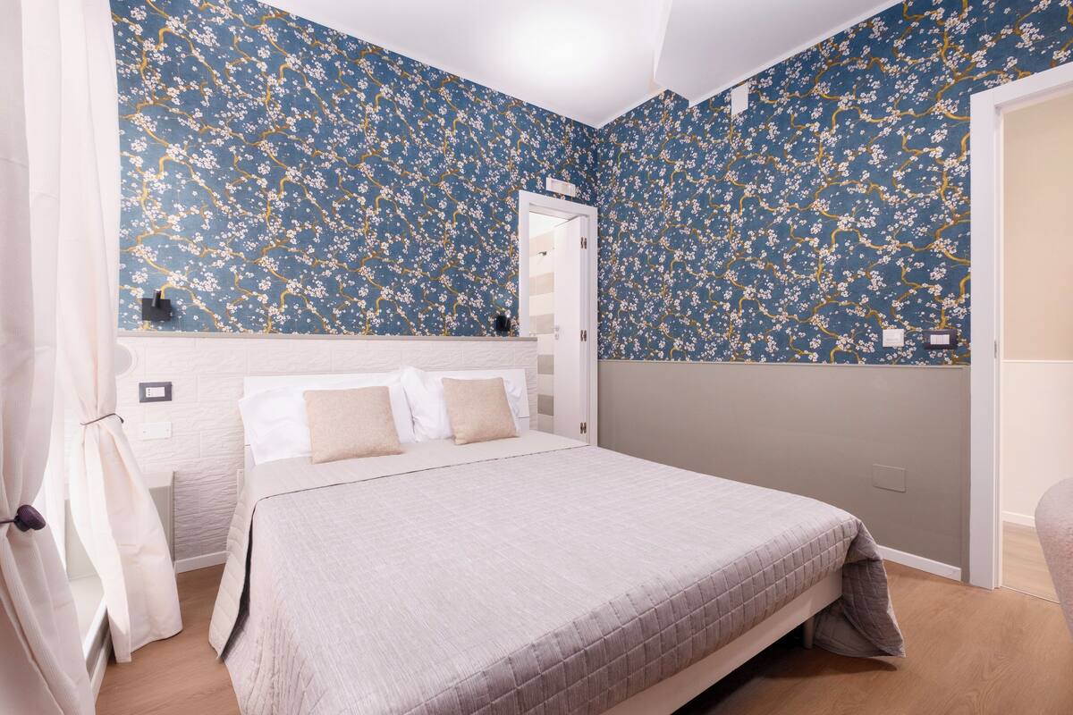 Une chambre à coucher comprenant un lit, une armoire et une porte donnant sur une autre pièce.