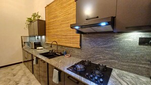 A modern kitchen with a gas stove, a sink, and a built-in oven. - Elegant Resort Hiriketiya (Dikwella)