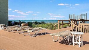 Terraza con sillones y mesas con vistas a la playa.