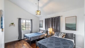 A bedroom with two beds, a window with curtains, a hanging plant, and a painting on the wall. - Heart of DT Alhambra Walk to Starbucks Near DTLA A (Alhambra)