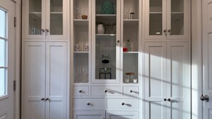 A white, multi-tiered storage unit with glass doors, featuring various compartments and drawers. - Cozy Private Home | Near DC & Military Bases (Indian Head)
