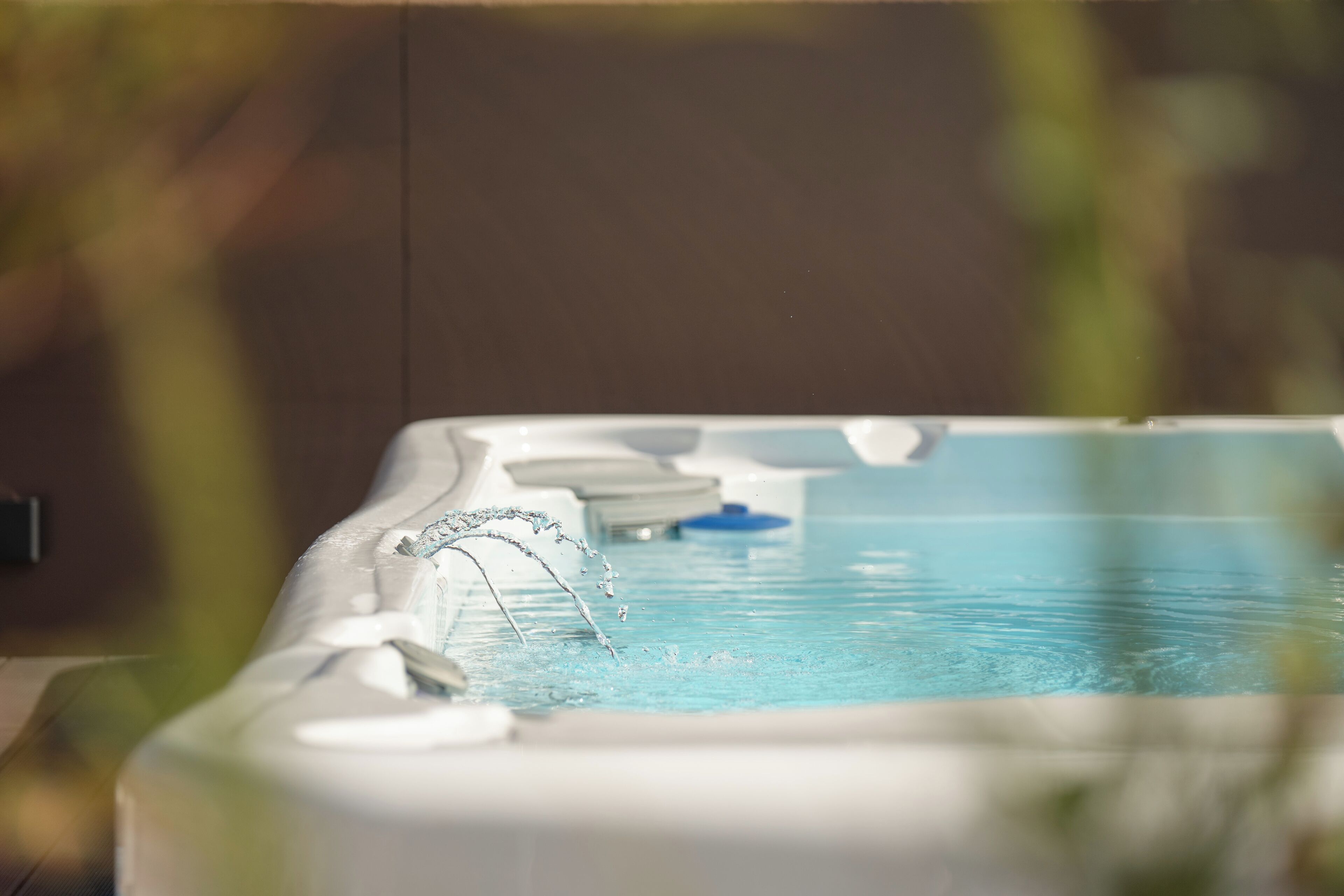 A hot tub with water jets, surrounded by indoor plants.