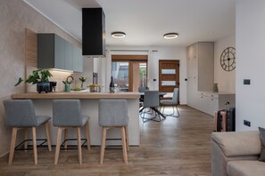 A modern kitchen with a central island, bar stools, and a dining area with chairs. - House 2415/192055 (Istria - Vodnjan), 5500m from the beach (Vodnjan)