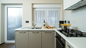 Une cuisine moderne dotée d’un îlot central, d’un four encastré et d’une cuisinière à gaz.