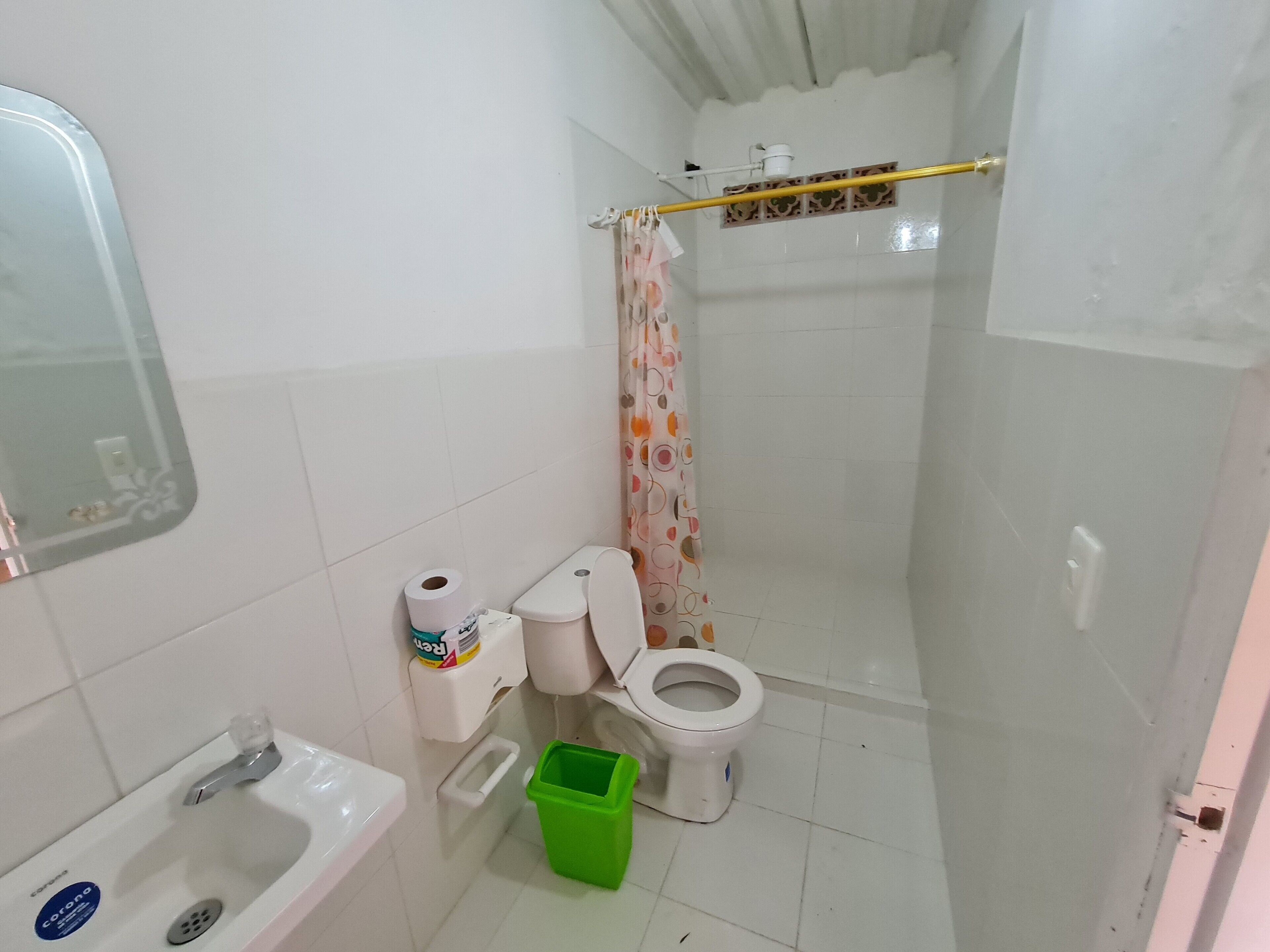 A small bathroom with a toilet, a sink, and a shower area.