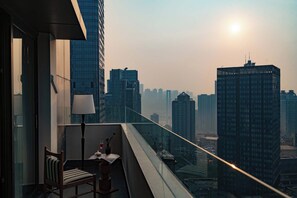 A balcony with a chair, a table, and a lamp. - Joyee Sky City Hotel Chongqing-Jiefangbei (Chongqing)