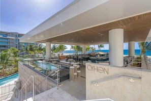 Eine Dachterrasse mit Pool, Sitzgelegenheiten im Freien und Blick auf den Ozean.