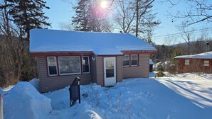 A two-story house with a snow-covered roof and a small front yard. - Cozy 2-bedroom house in Haines Falls near Katterskill falls . (Haines Falls)