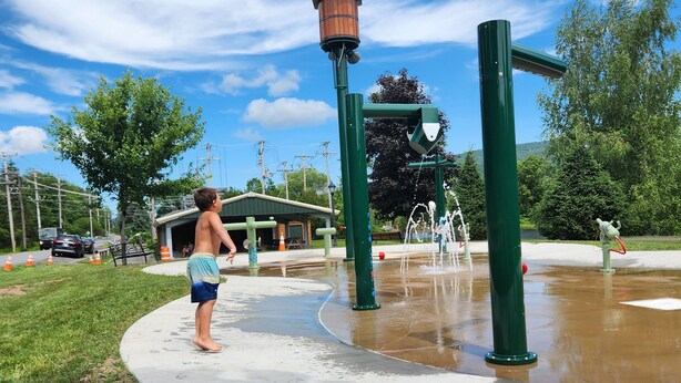 A playground with a water feature and a green structure. - Cozy 2-bedroom house in Haines Falls near Katterskill falls . (Haines Falls)