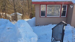 A house with a snow-covered roof and a small porch area. - Cozy 2-bedroom house in Haines Falls near Katterskill falls . (Haines Falls)