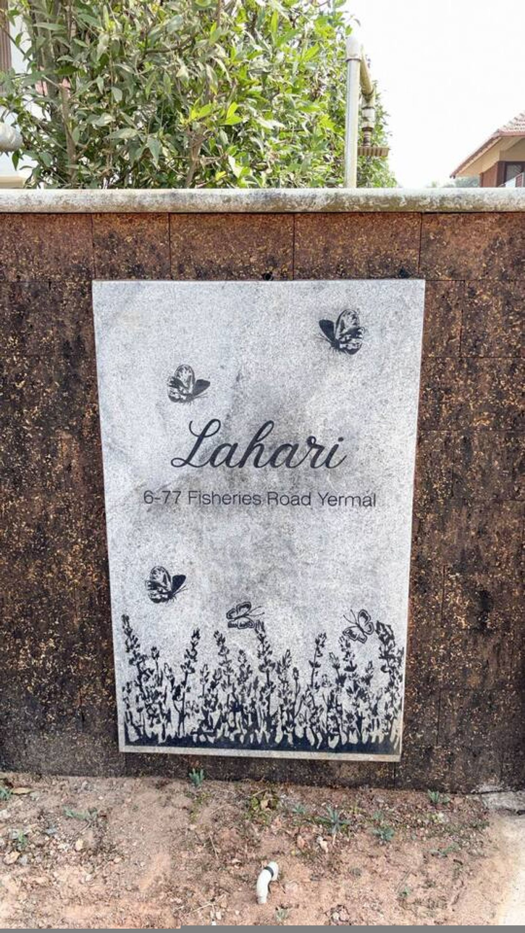 A sign with the name "Lahari" and an address "6-77 Fisheries Road Yermal".