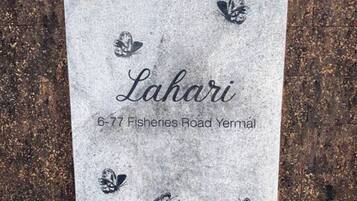 A sign with the name "Lahari" and an address "6-77 Fisheries Road Yermal".