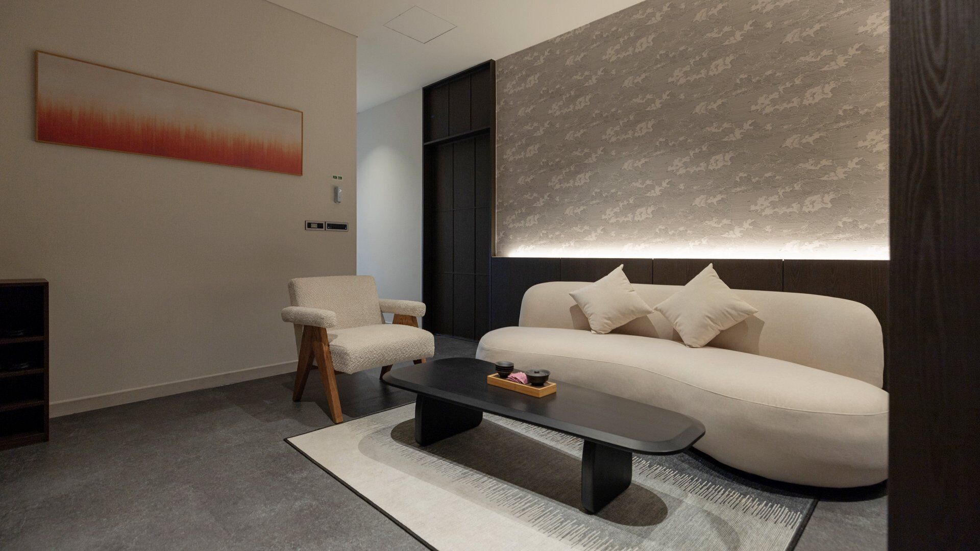 A modern living room with a sofa, armchair, and coffee table.