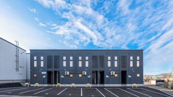 A modern building with a parking lot in front.