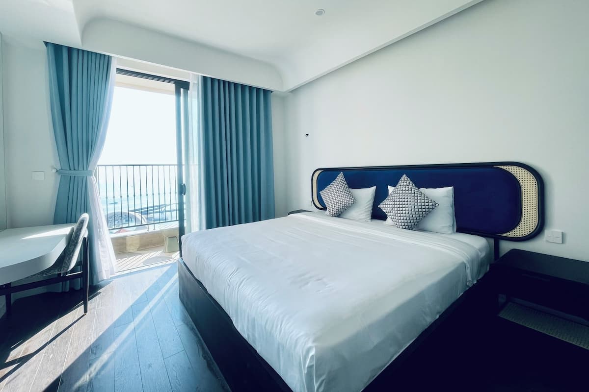 Una habitación de hotel con una cama, un escritorio y un balcón.