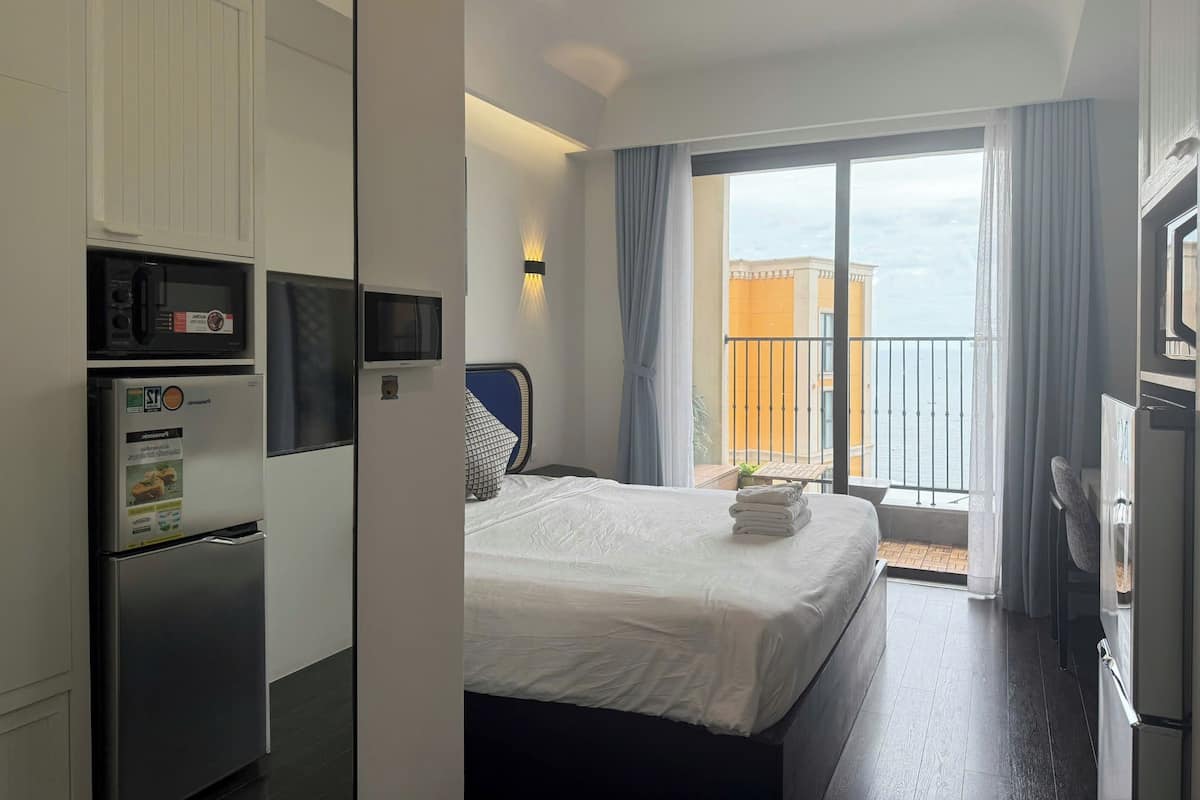 Habitación de hotel con cama, televisor, microondas y refrigerador.
