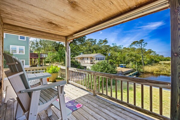 A wooden deck with a view of a lake and surrounding greenery.