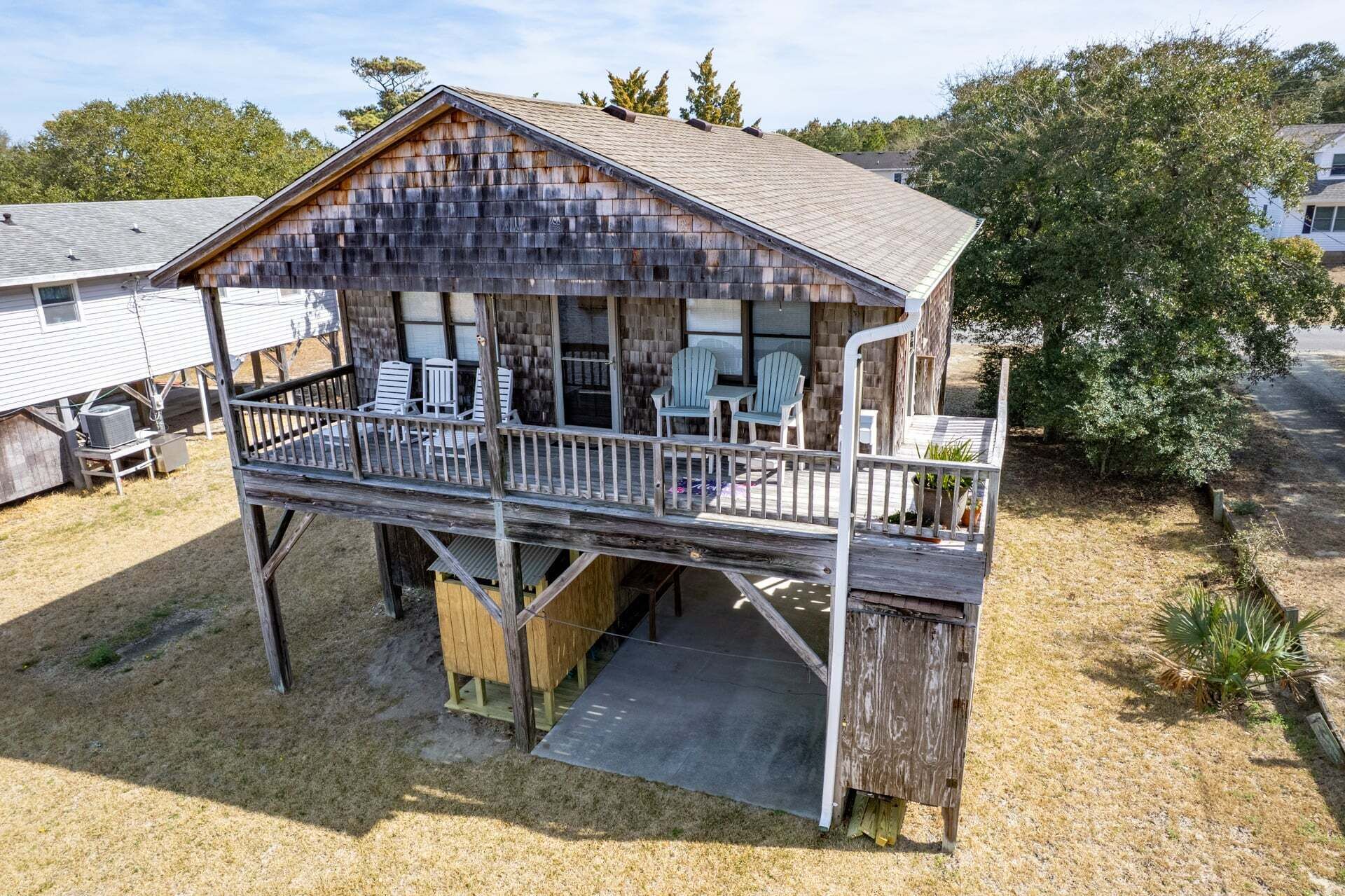 A wooden cabin with a balcony, outdoor seating, and a small deck area.