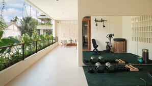 Ein geräumiger Balkon mit Fitnessbereich, inklusive Kurzhanteln und Trainingsgeräten.