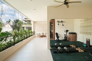 Ein geräumiger Balkon mit Fitnessbereich, inklusive Kurzhanteln und Trainingsgeräten.