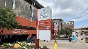 A sign for Allina Health United Hospital with directions to the main entrance, drop-off/valet, and Blue Ramp parking. - Bright, cozy & cute in St. Paul by Summit-University with porch and swing chair (Saint Paul)