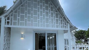 A white building with a triangular roof and a glass door entrance. - Riomana Villas Resort and Cafe (Cateel)