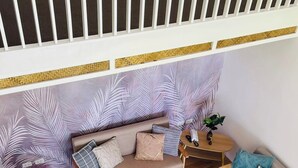 A cozy living area with a sofa, two armchairs, a small round table, and a patterned rug. - Riomana Villas Resort and Cafe (Cateel)