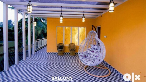 A balcony with a checkered floor, hanging chairs, and pendant lights.