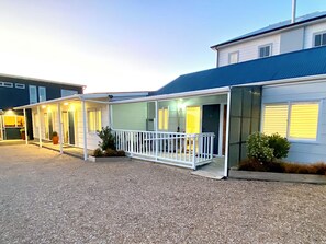 A two-story building with a covered outdoor area and a gravel driveway. - Pioneer Motel (Collingwood)
