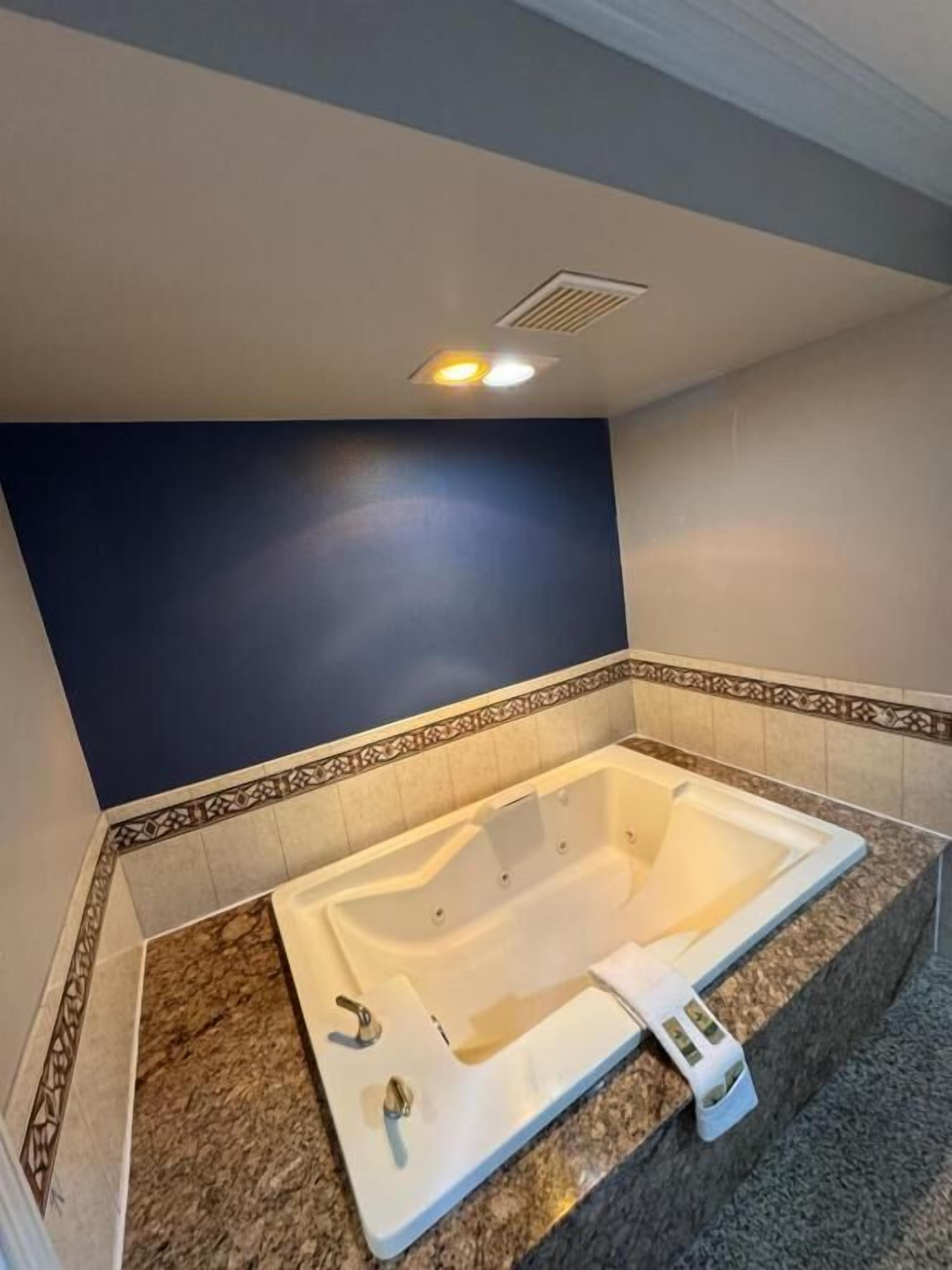 Ein Badezimmer mit einer großen Badewanne, einer Dusche und einer Toilette.