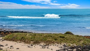 A beach with waves, rocks, and grass. - Fisherman's Rest - Your Perfect Couple’s Retreat (Port Fairy)