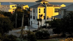 Un quartier résidentiel situé sur la côte, avec des maisons, un ciel dégagé et une vue sur l’océan.