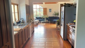 Una cocina amplia con piso de madera, horno empotrado y refrigerador.