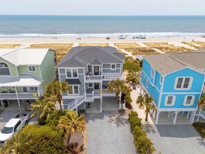 A beachfront property with multiple houses, a beach view, and a parking area. - Hobbs Realty - "Waves of Grace": Elegant Oceanfront Home with Stunning Views and Private Pool (Holden Beach)