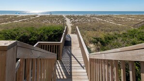 A wooden boardwalk leading to a beach with a clear view of the ocean. - Dolphin's Watch: A stunning oceanfront 4BR retreat in Supply, NC, perfect for 10 guests. (Supply)