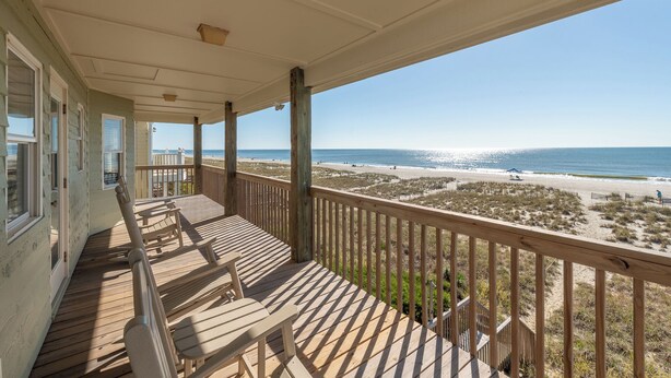A wooden deck with a view of the beach. - Dolphin's Watch: A stunning oceanfront 4BR retreat in Supply, NC, perfect for 10 guests. (Supply)
