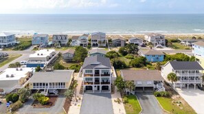 A coastal residential area with houses, a beach, and a clear view of the ocean. - Sunset Skies: Stylish 4BR beach home in Holden Beach with a private pool. (Holden Beach)