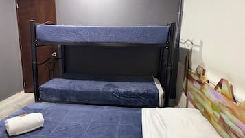 Una cama litera con un colchón azul, una almohada blanca y una toalla blanca enrollada en la litera inferior.