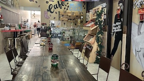 A cafe with wooden tables and chairs, a coffee display, and a Christmas decoration. - Tu Hotel Chía (Chía)