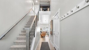 Eine moderne Treppe führt zu einer zweiten Etage, mit Blick auf einen Essbereich darunter.
