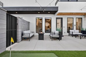 A modern outdoor patio with seating and a fire feature. - Pecan Valley l Sunset Splash l Private Waterpark (Hurricane)