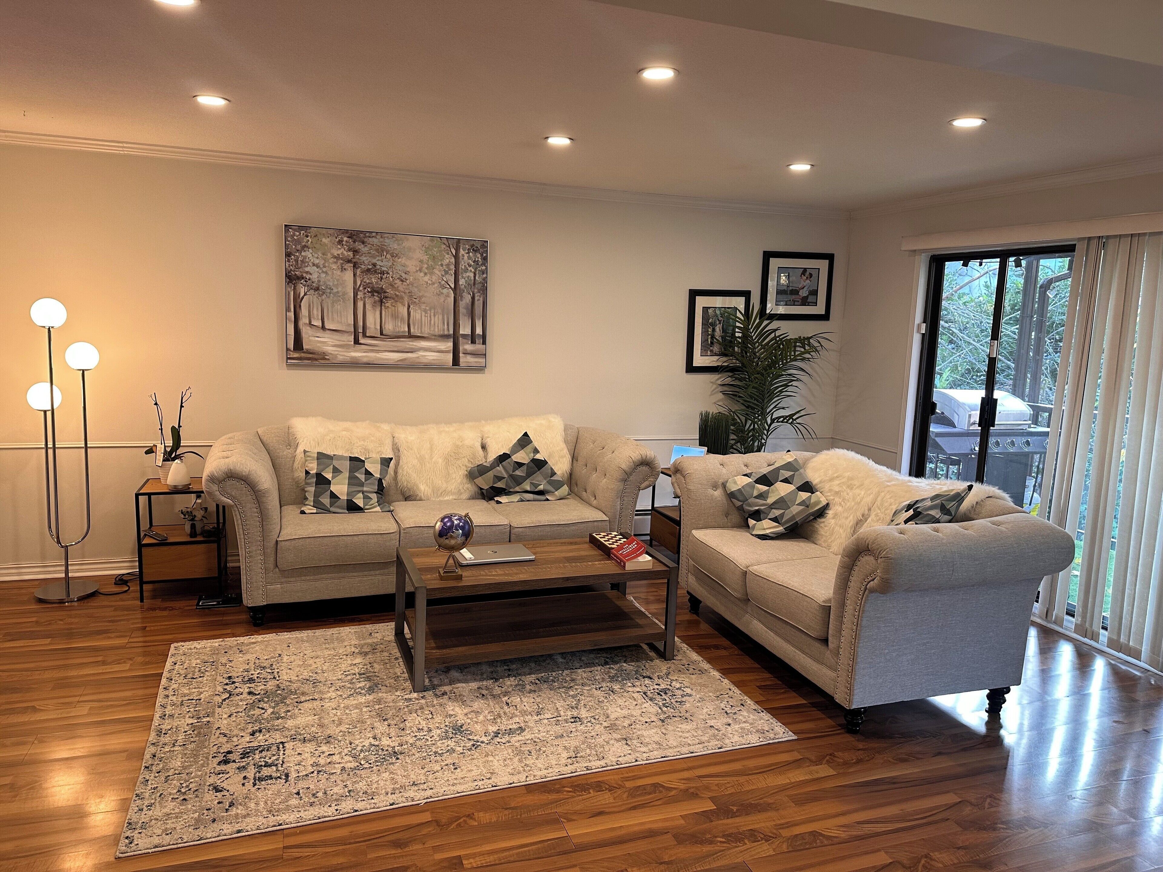 A living room with two sofas, a coffee table, a rug, and a floor lamp.