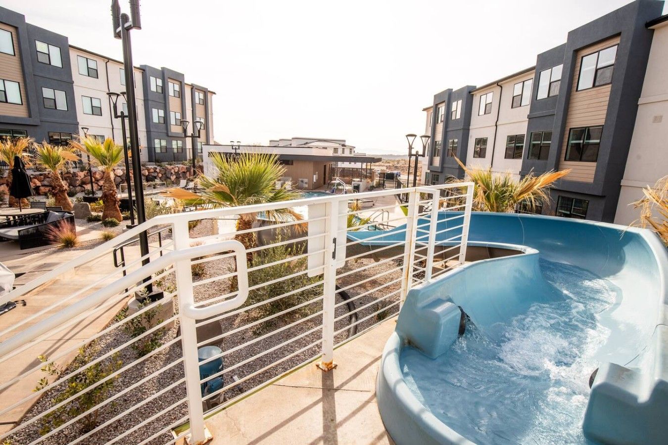 A residential area with a swimming pool, outdoor seating, and modern buildings.