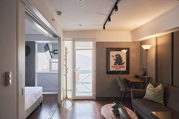 Une chambre d’hôtel moderne, équipée d’un lit, d’un canapé, d’une table à manger et d’un tableau encadré au mur.