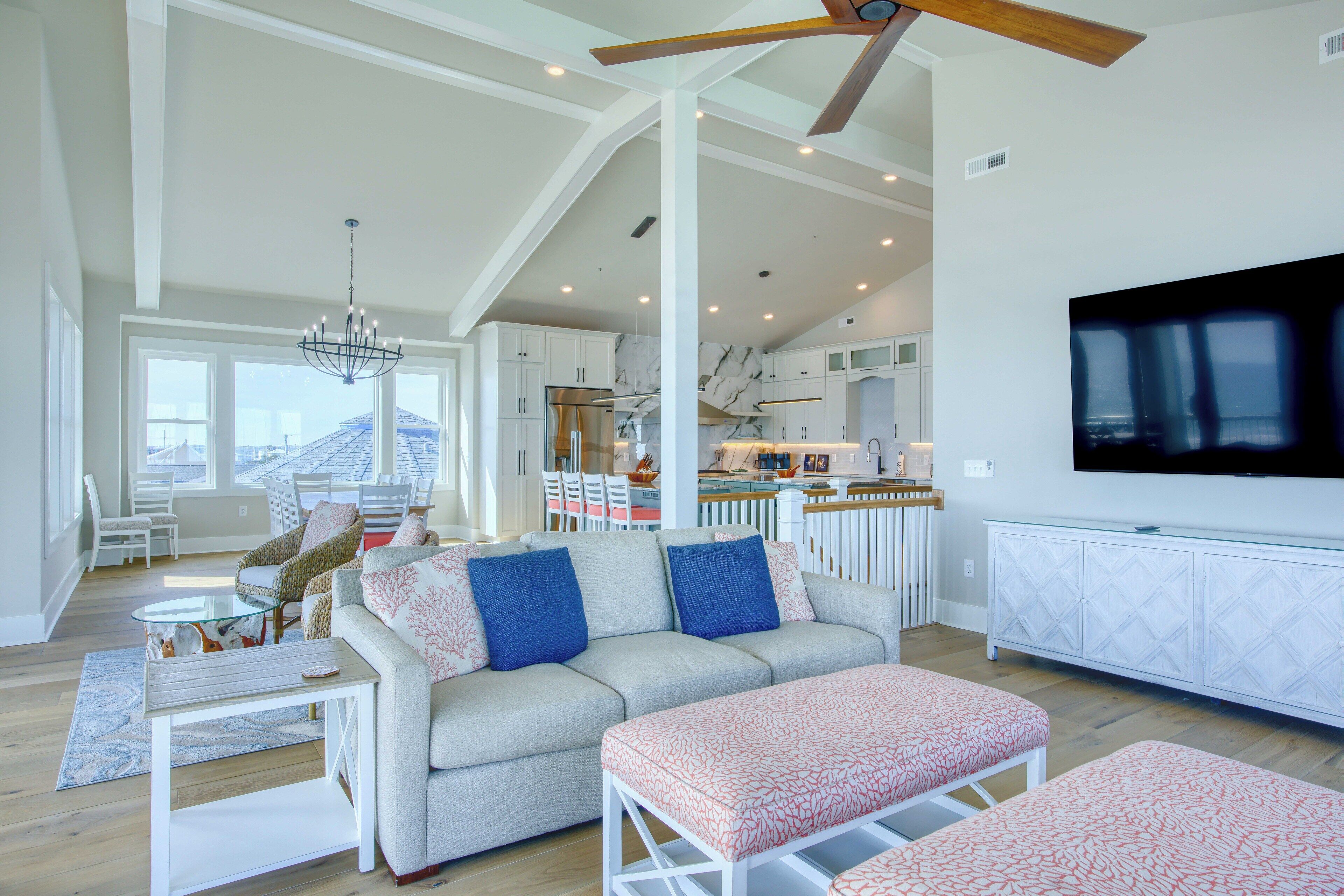 A spacious living room with a sofa, ottoman, and dining area.