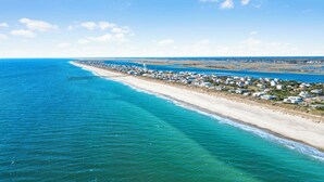 A coastal town with a long pier extending into the ocean, surrounded by residential buildings. - Atlantis | Ocean Views, Private Saltwater Pool, Elevator, Pets, Beach access (Topsail Beach)