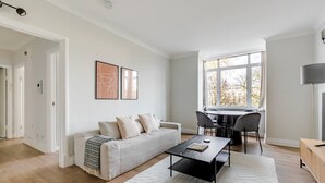 Un salon moderne avec un canapé, une table basse et un coin repas.
