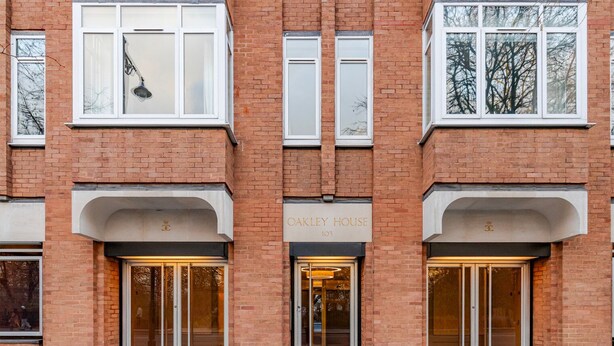 Un bâtiment en briques avec une enseigne indiquant « OAKLEY HOUSE 103 » au-dessus de l’entrée.